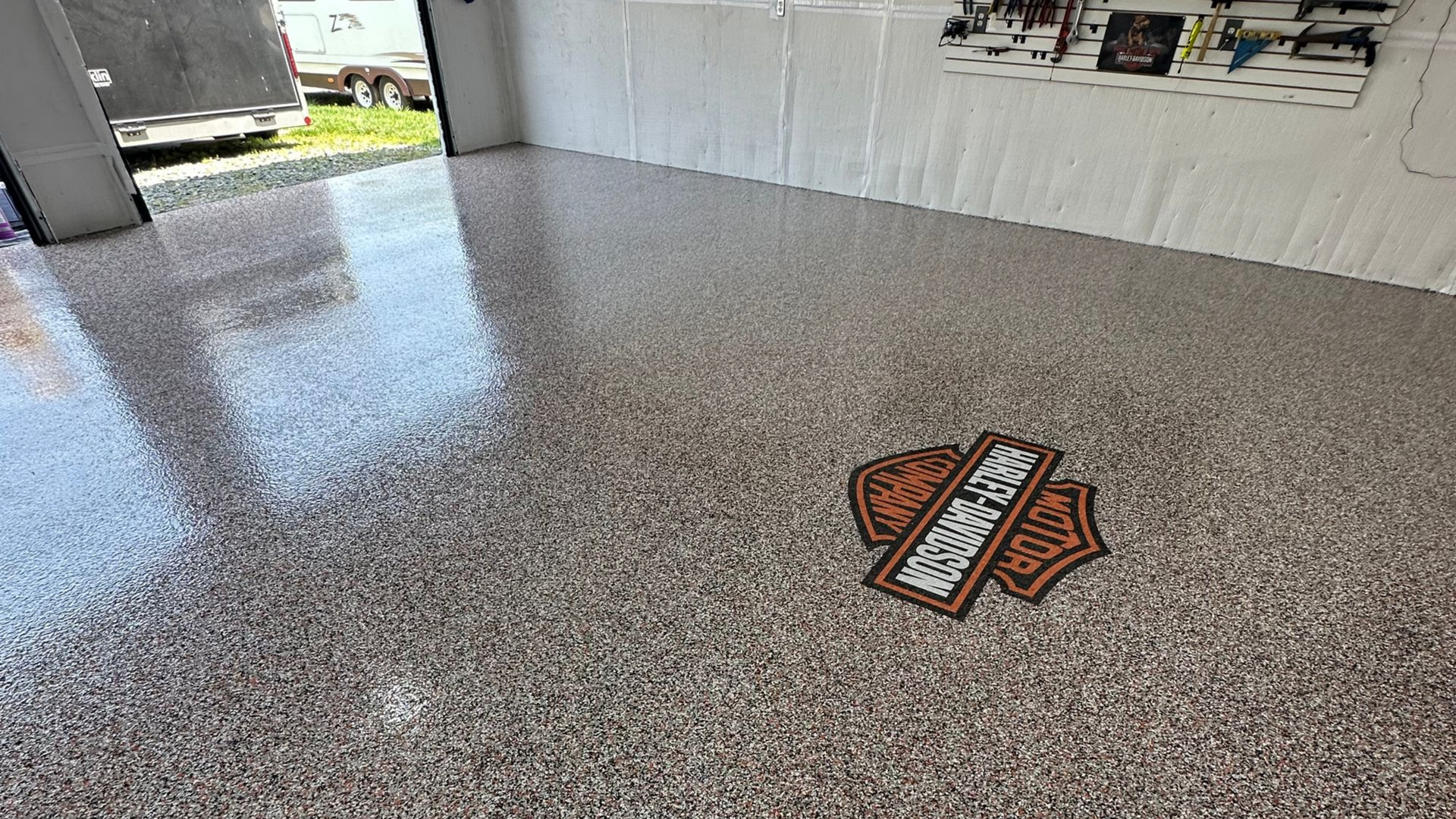 Speckled epoxy floor with a Harley-Davidson logo in a garage or showroom