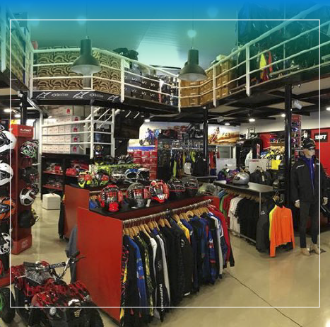 Interior de una tienda de artículos deportivos para actividades al aire libre con estantes de cascos, chaquetas