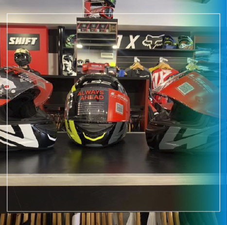 Tres cascos de carreras en una vitrina, negros y rojos con detalles en amarillo neón.