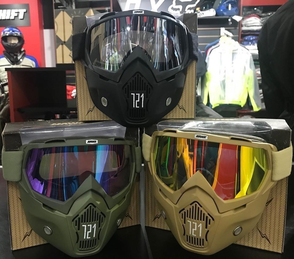 Se exhiben tres gafas de motocross, dos de color verde oliva y una negra, con lentes espejadas.