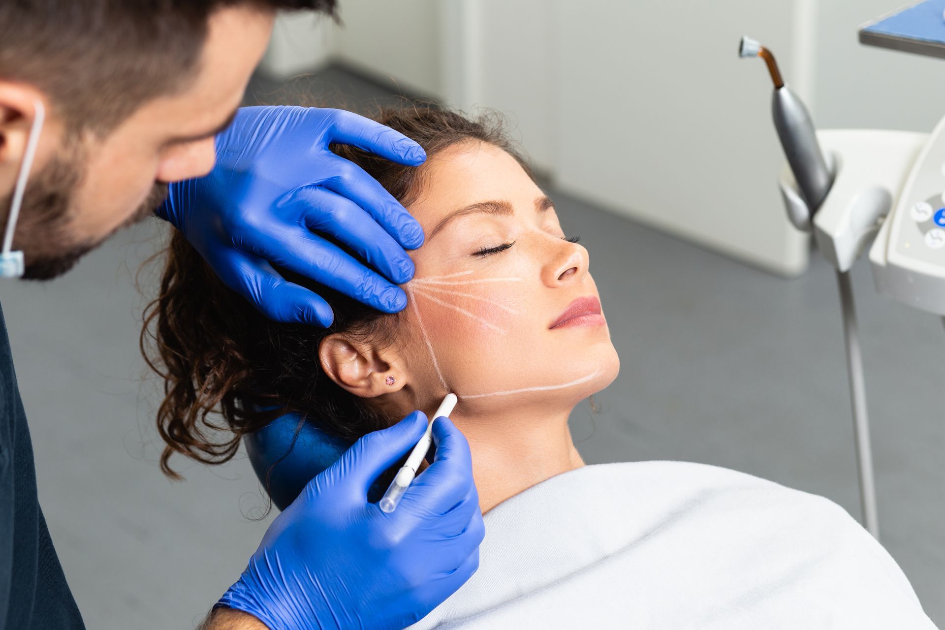 Close-up of a cosmetic procedure on a woman's face by a gloved practitioner in a clinic.