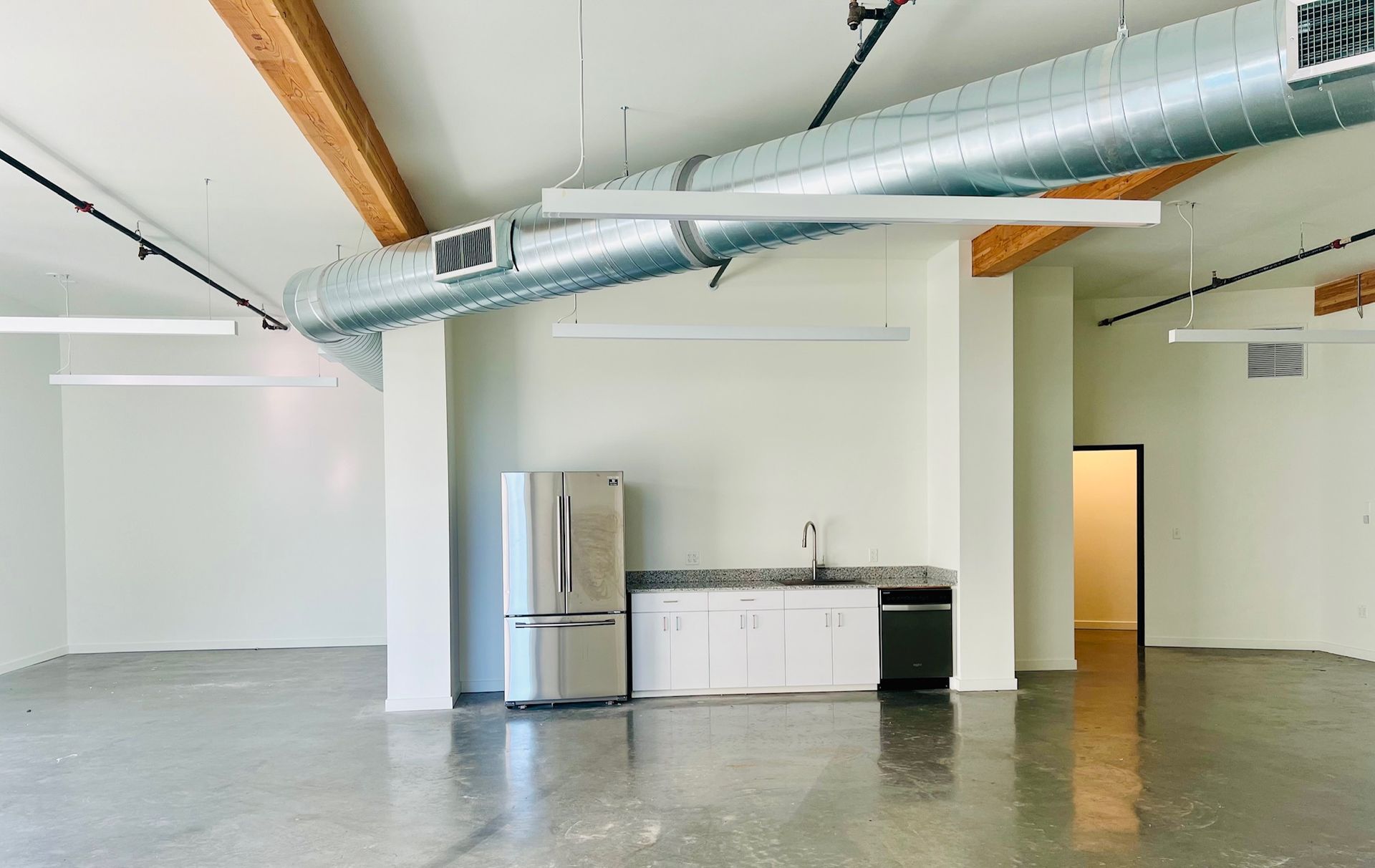An empty room with a refrigerator and a sink