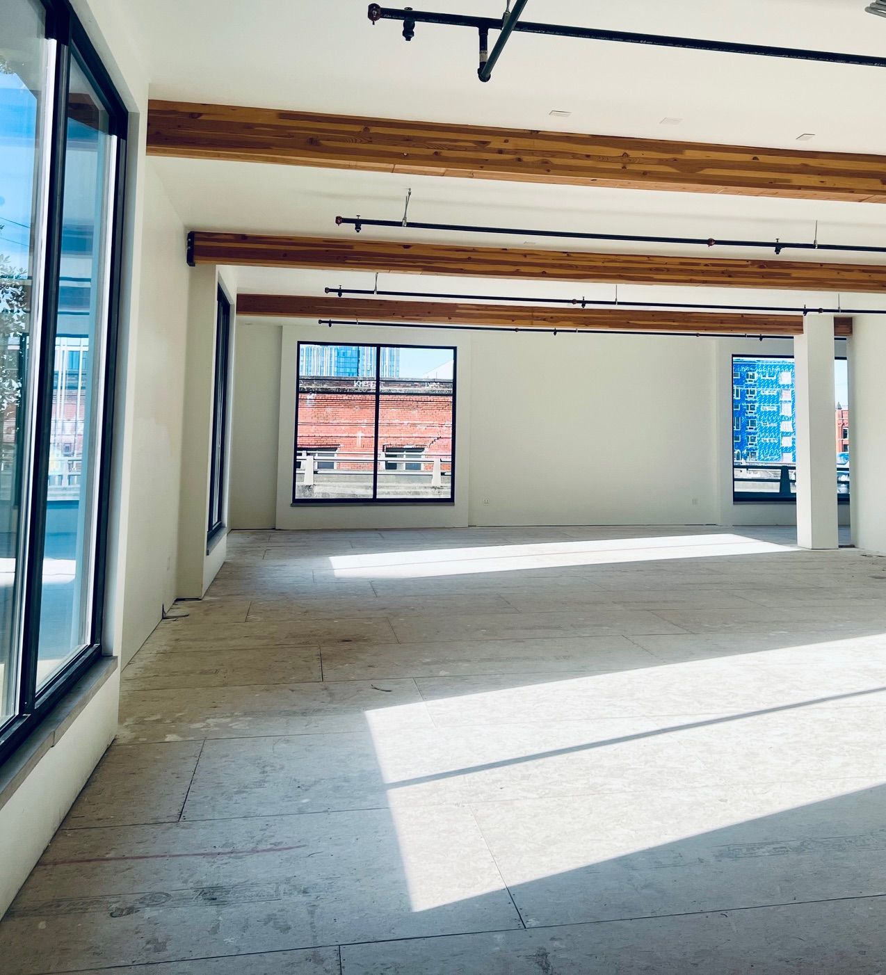 An empty room with a lot of windows and wooden beams