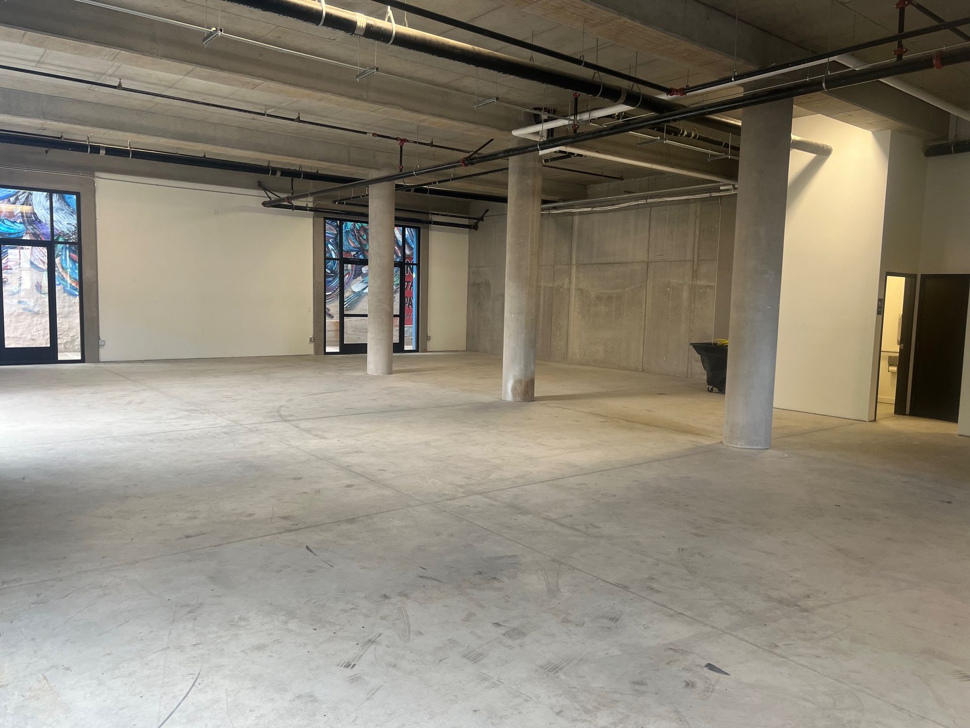 A large empty room with a lot of windows and columns.