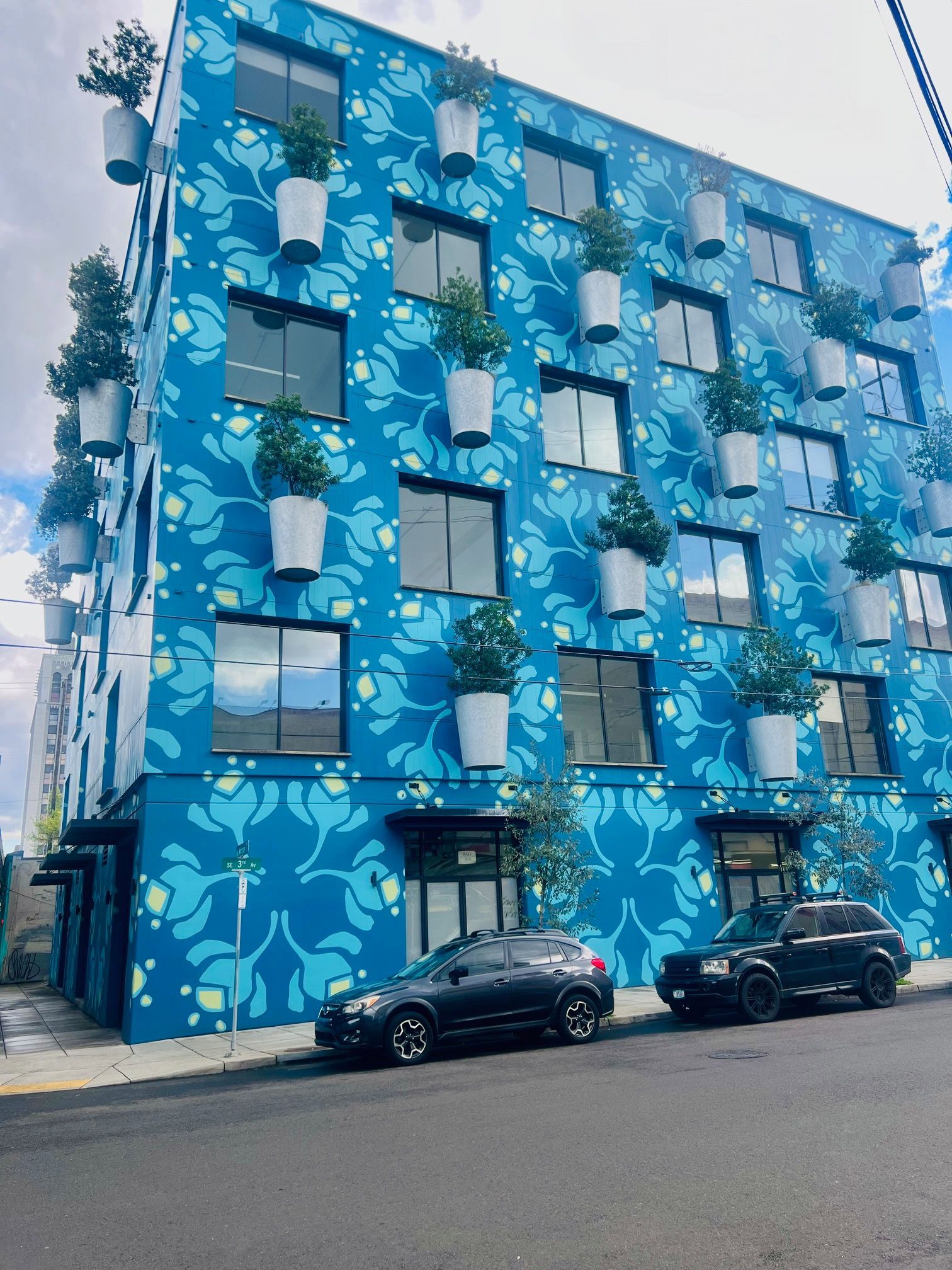 A blue building with a lot of potted plants on it