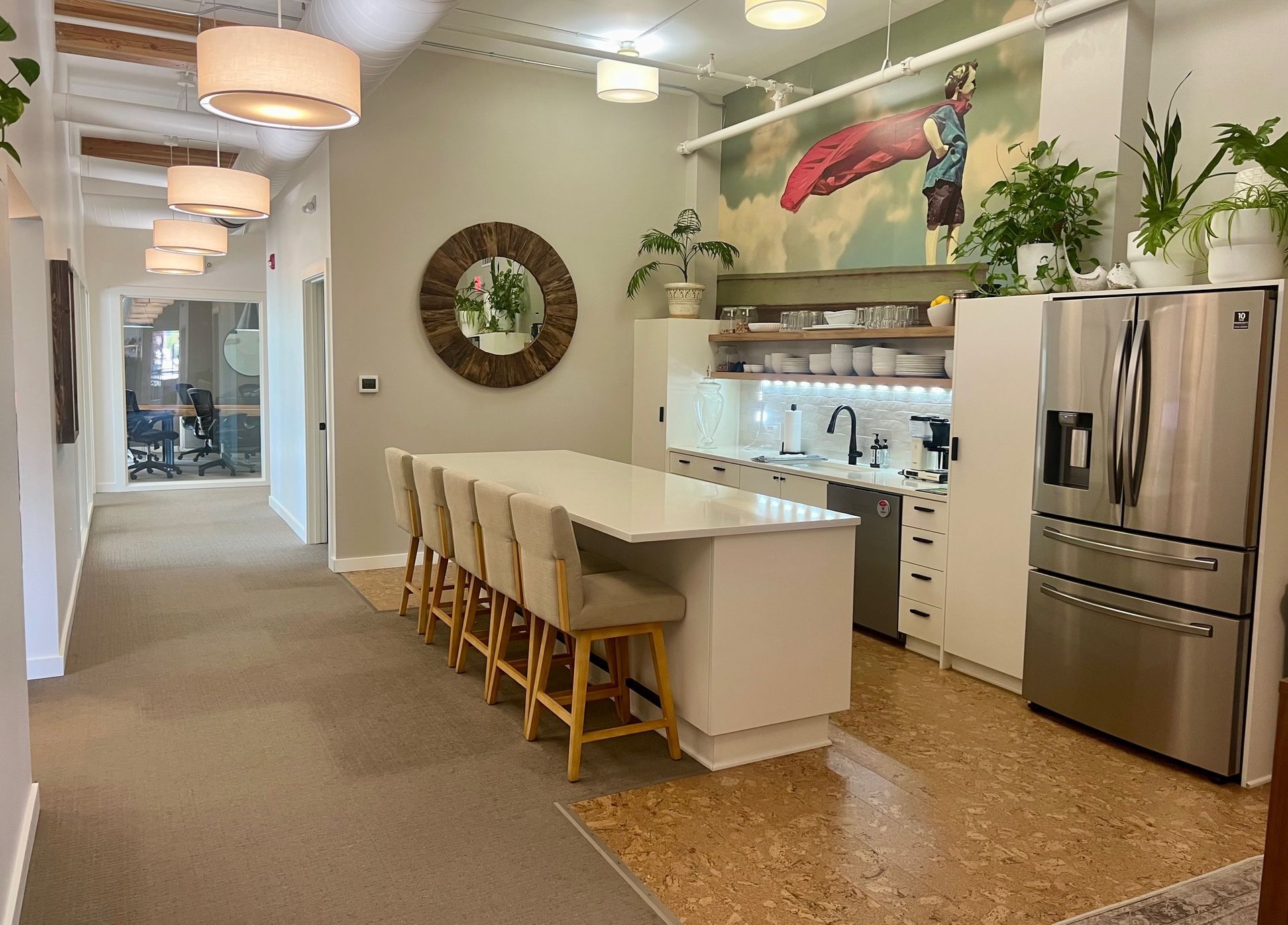 A kitchen with a long island , stainless steel appliances , and a refrigerator.