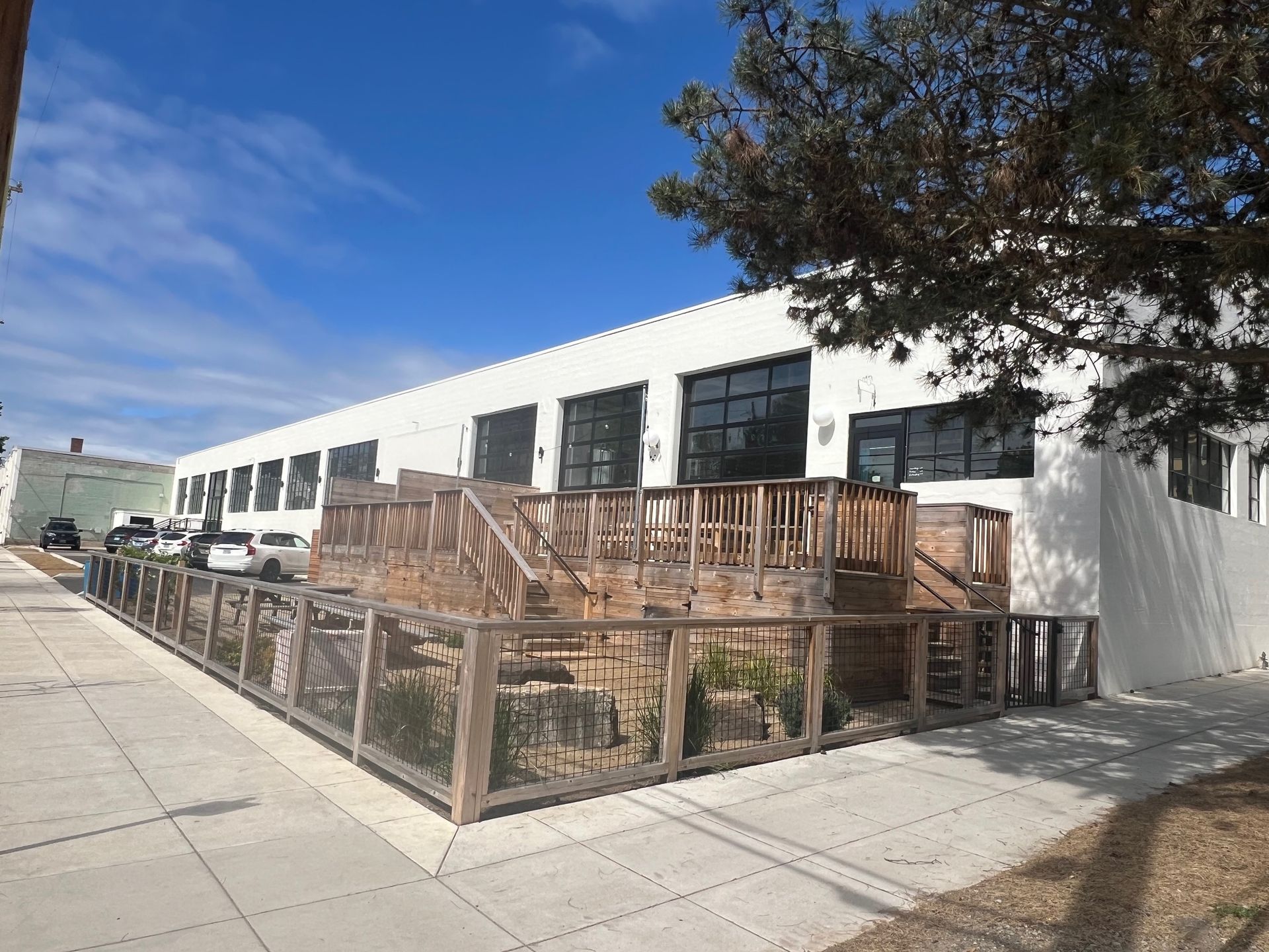 A large white building with a wooden deck in front of it.