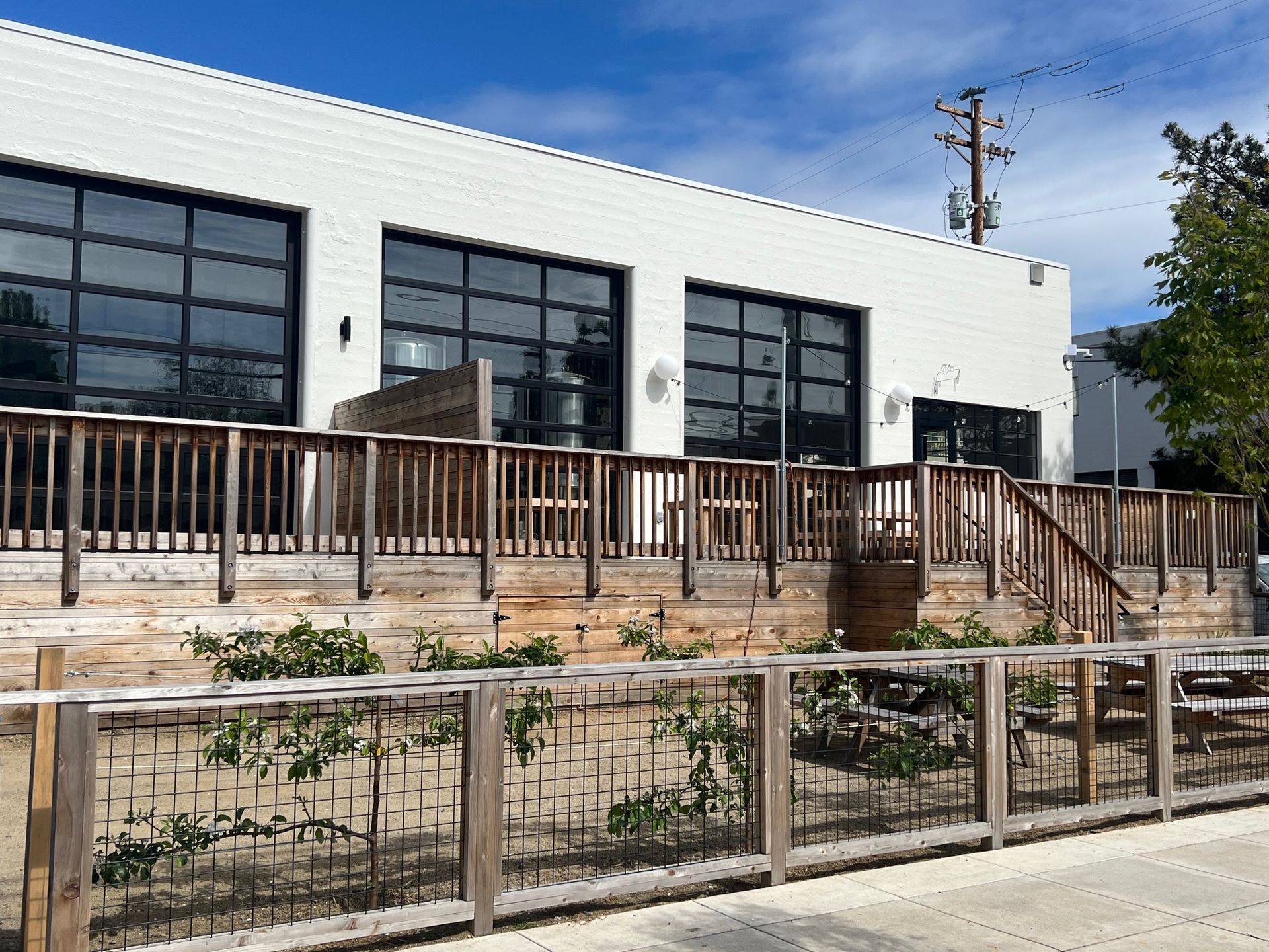 A white building with a wooden deck and stairs in front of it.