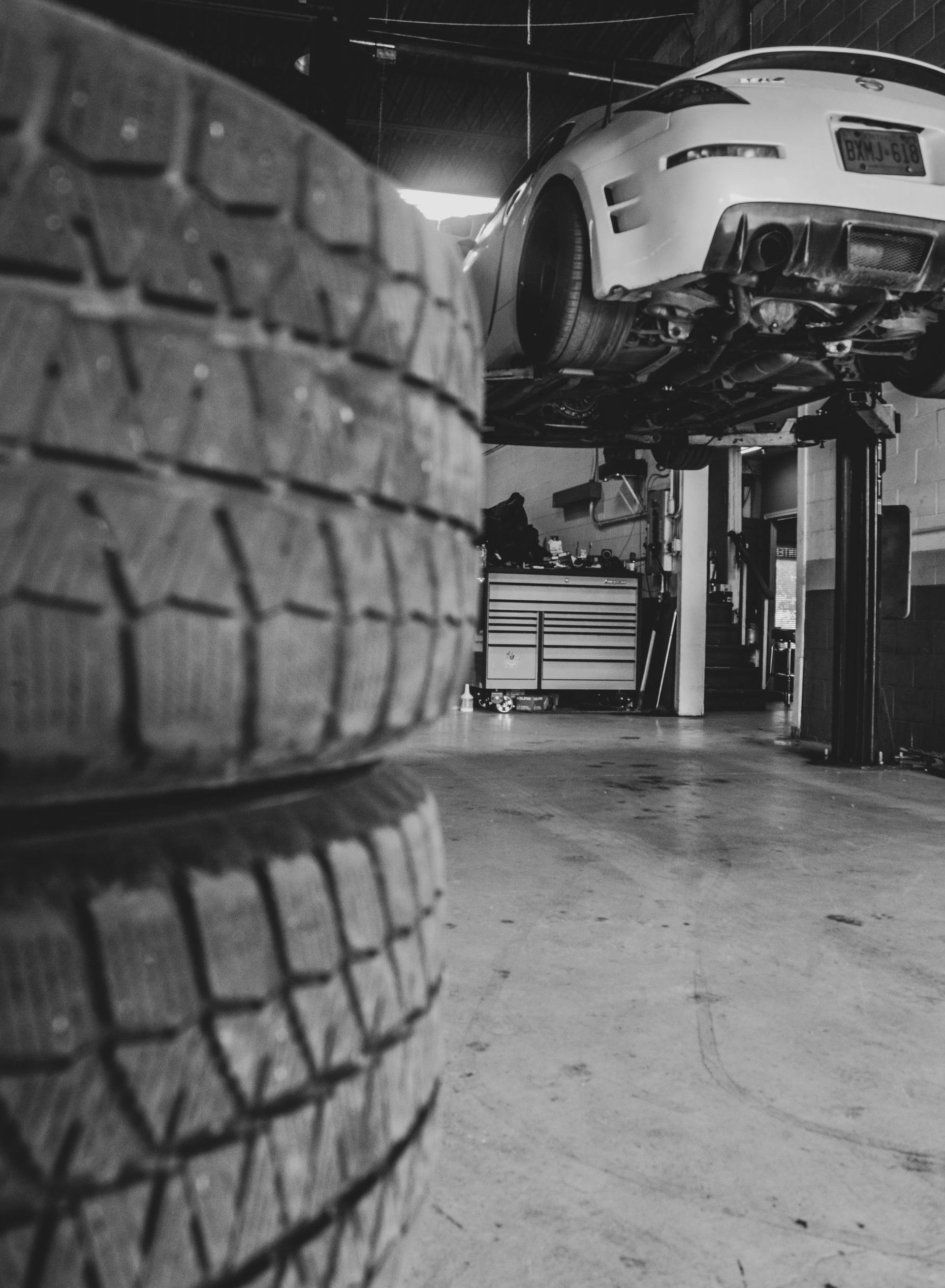 White car lifted on a hydraulic jack in an auto repair shop