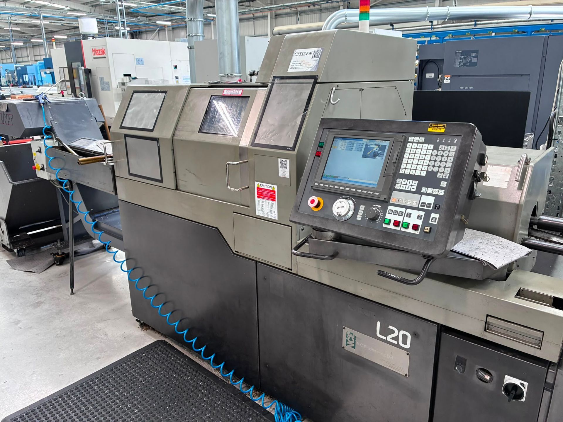 A large machine is sitting in a factory next to a green table.