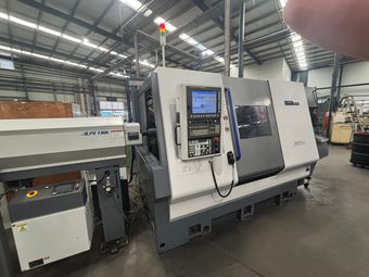 A machine is sitting in a warehouse next to a couch.