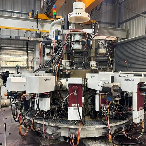 A machine is sitting in a warehouse with a lot of wires coming out of it.