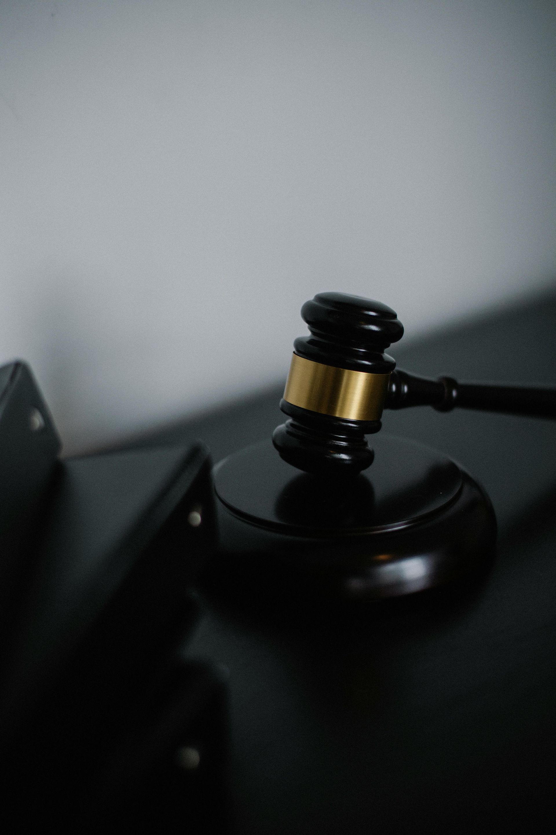 Wooden gavel on a sound block, used in a legal setting to finalize decisions.