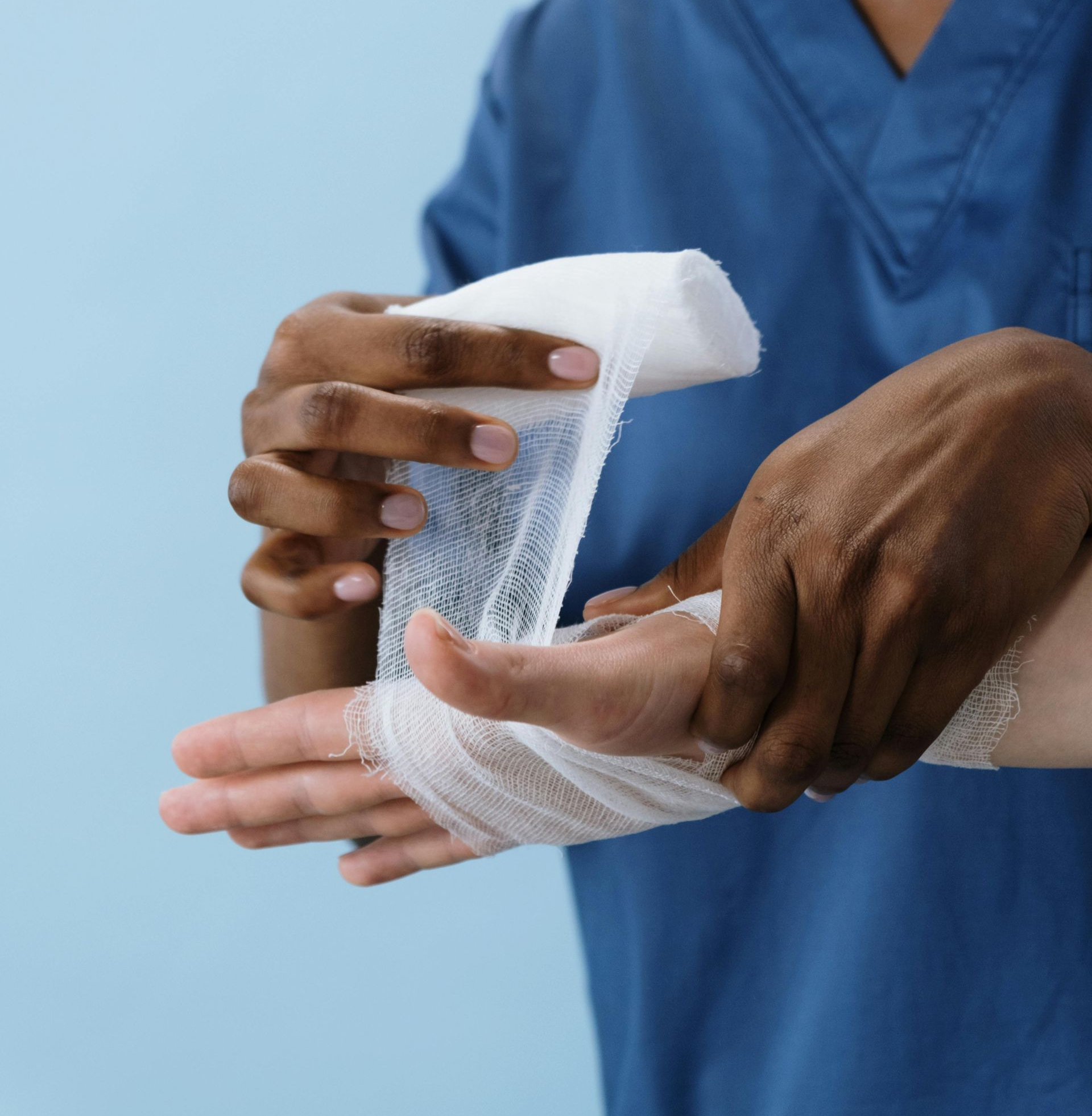 A nurse bandaging a patients hand