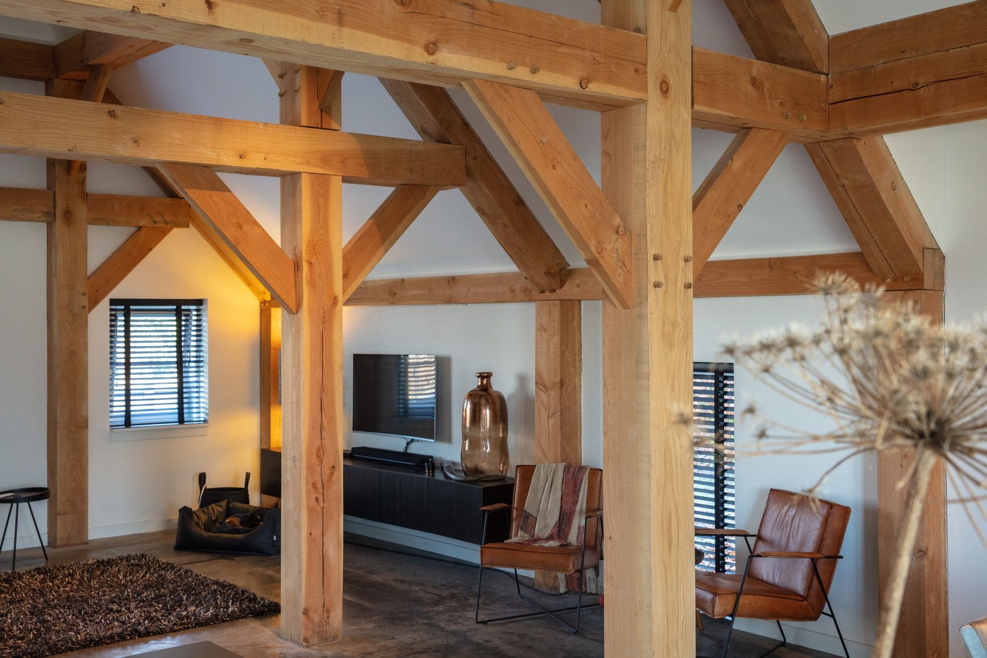 Een woonkamer met houten balken en een vloerkleed