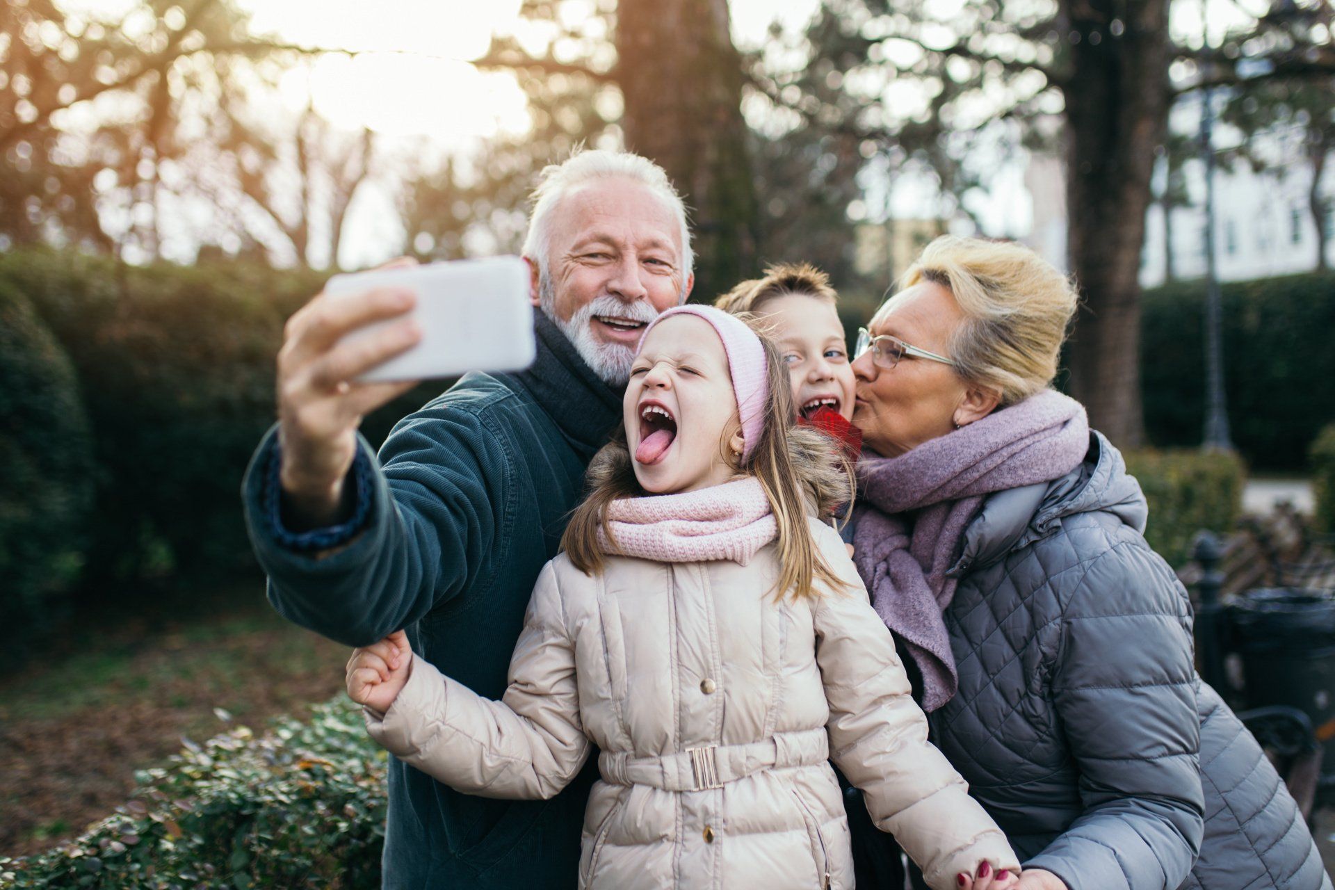 A family is taking a selfie together in a park.