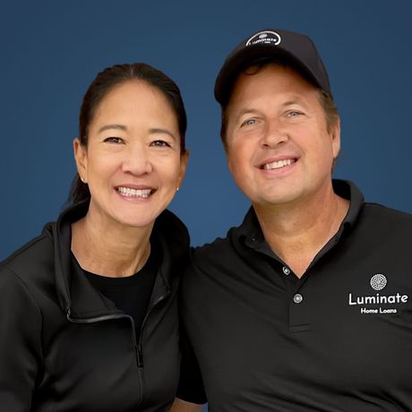 A man in a suit and a woman in a pink shirt are posing for a picture.
