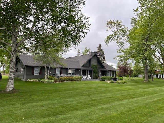 A large MN lake house with a large lawn in front of it
