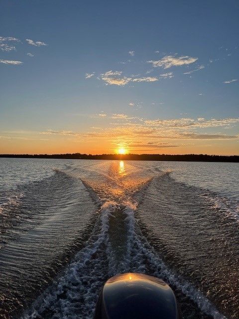 A person is riding a boat on a MN lake at sunset