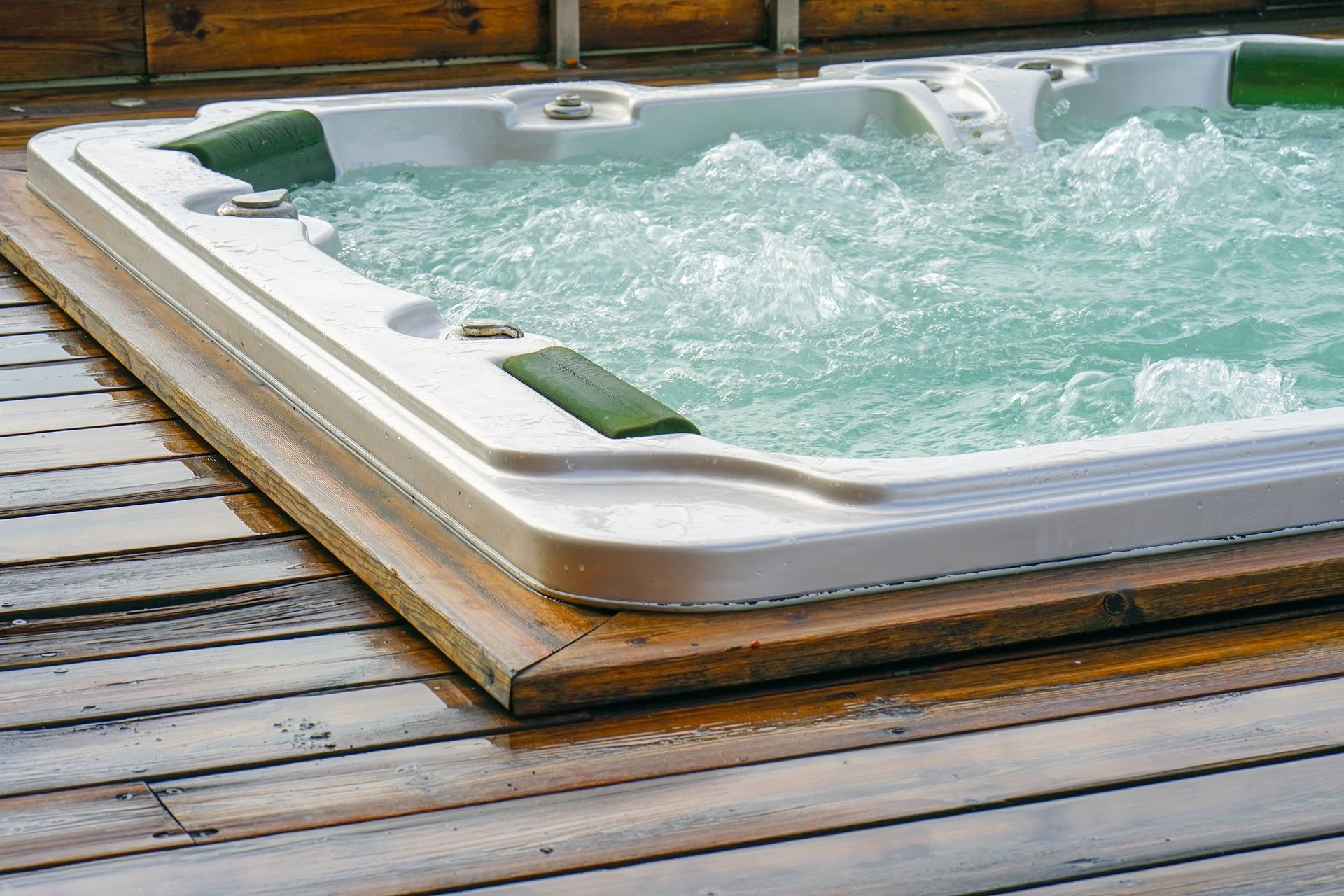 Un bain à remous est posé sur une terrasse en bois.