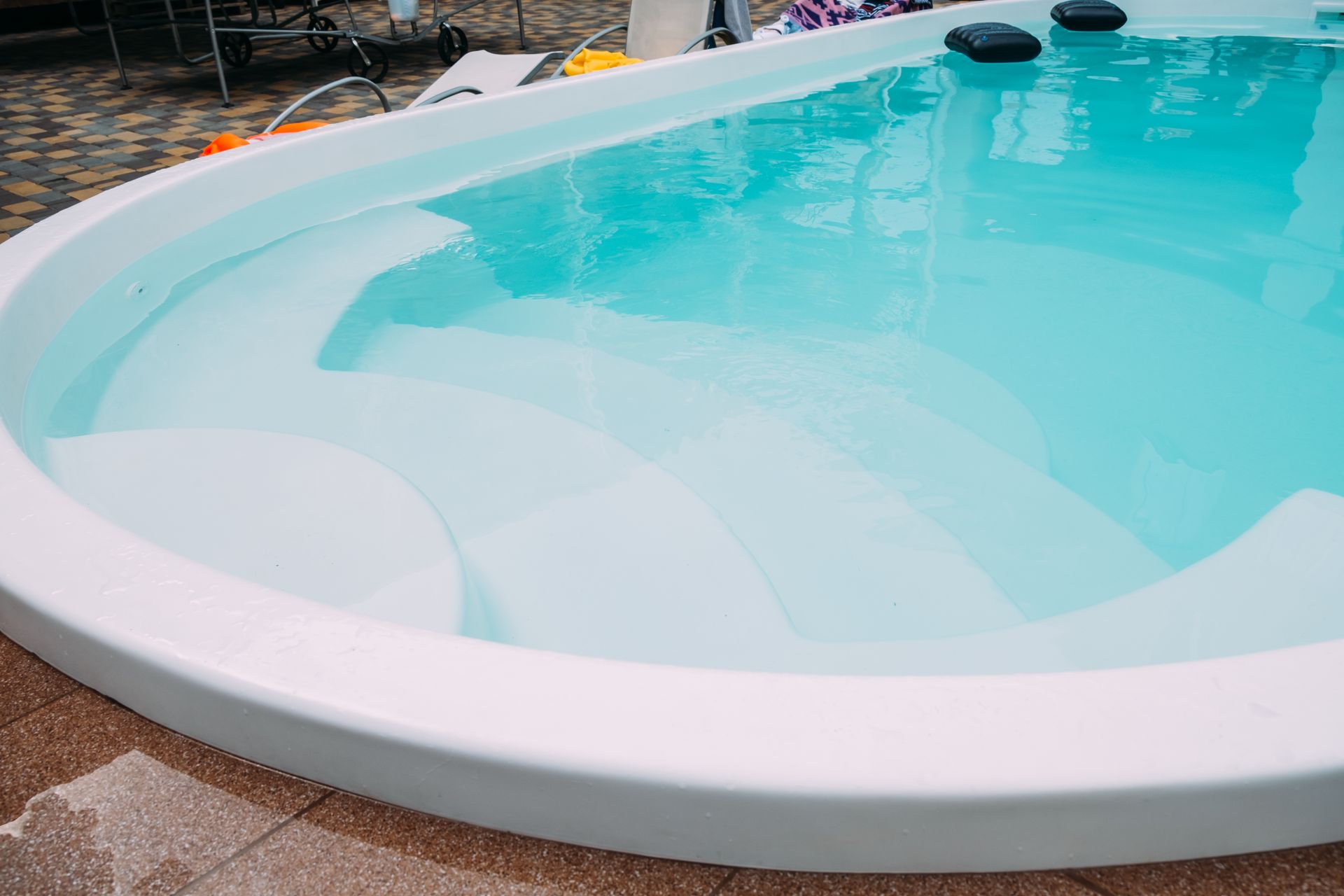 Une grande piscine remplie d'eau bleue et de marches blanches.
