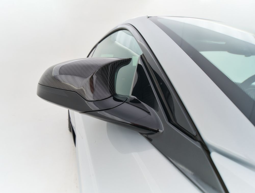 Un gros plan du rétroviseur latéral d'une voiture sur fond blanc