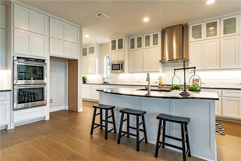 Modern kitchen with stainless steel appliances, including a stove, oven, and microwave..