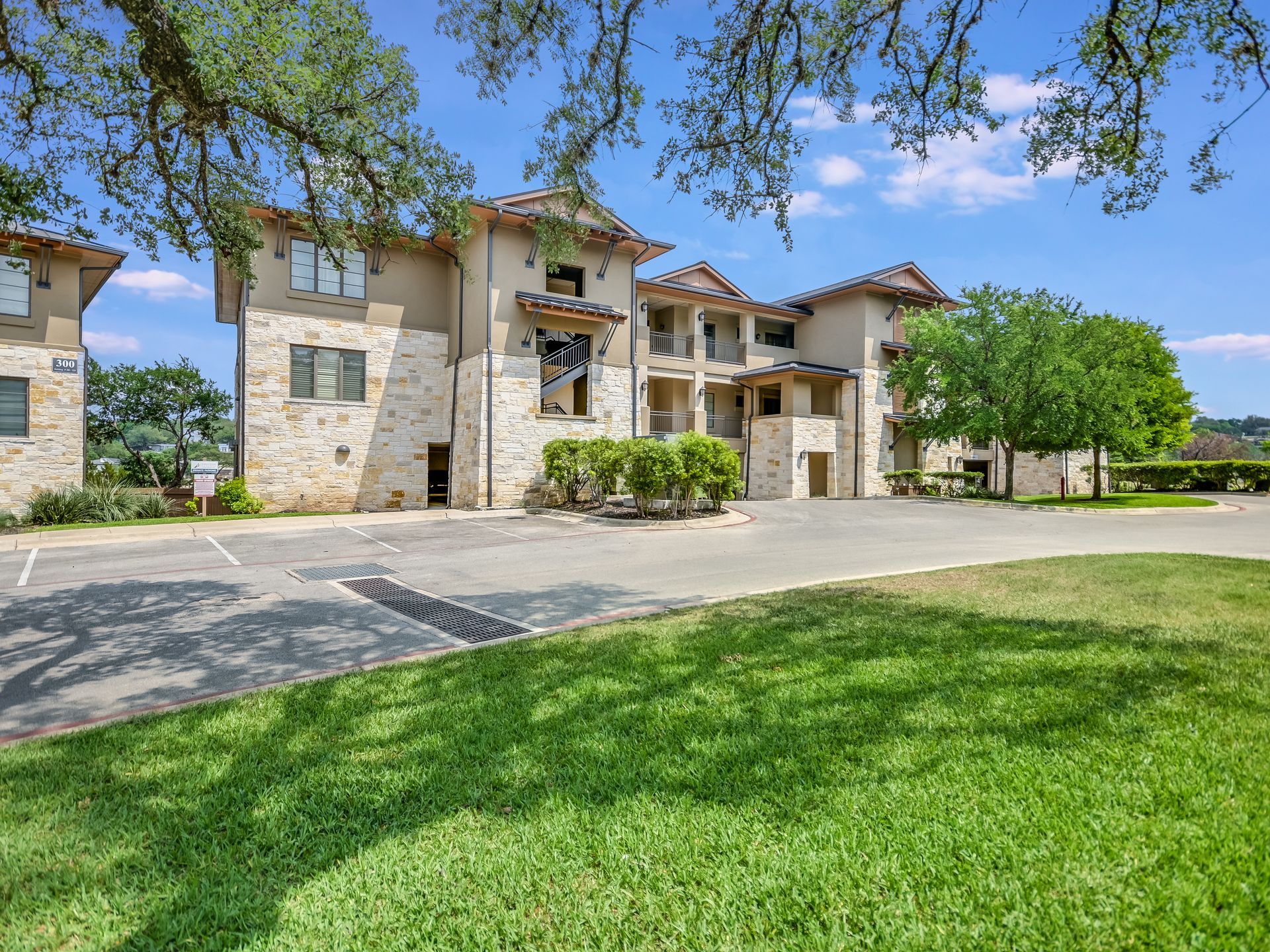 Beautiful luxury house in Texas with a spacious driveway, surrounded by lush landscaping and mature trees