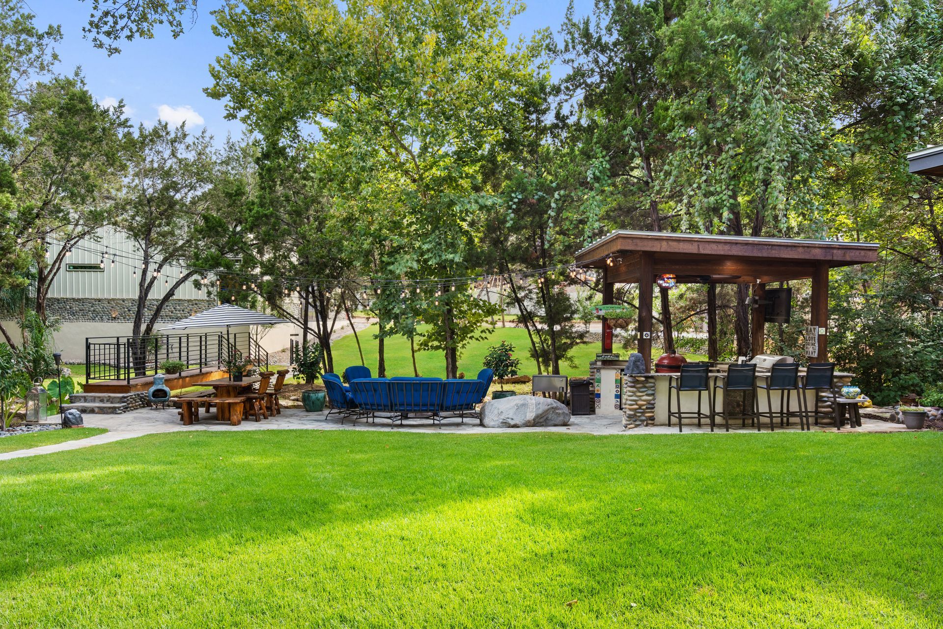 Backyard oasis with outdoor patio furniture, a barbecue grill, and verdant greens