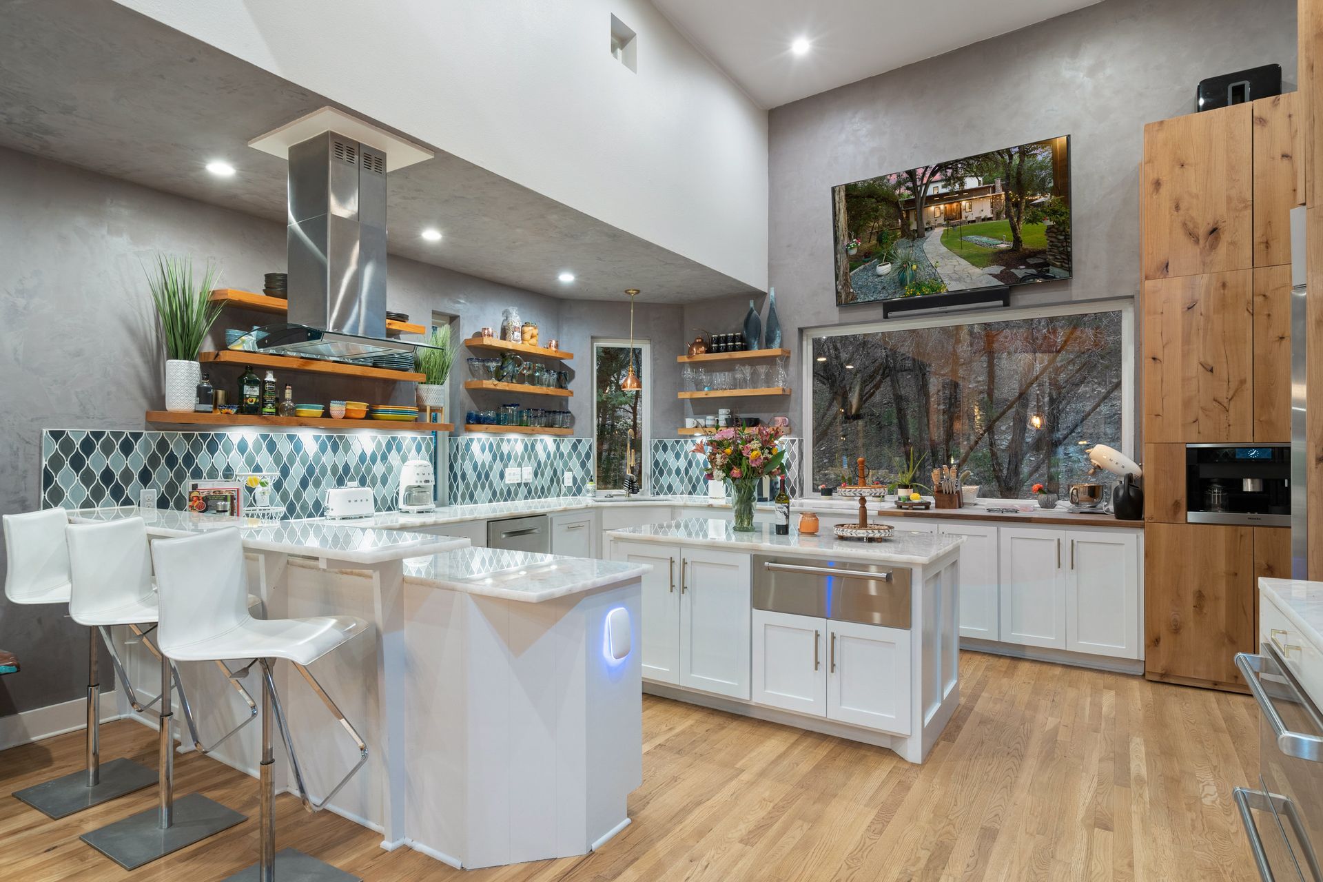 Clean and luxurious kitchen featuring white cabinetry and stainless steel appliances.