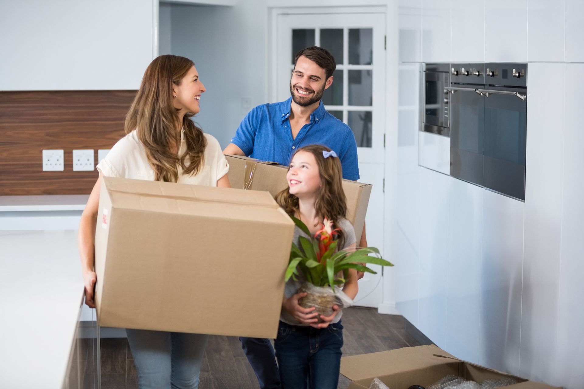 Family moving out holding a box