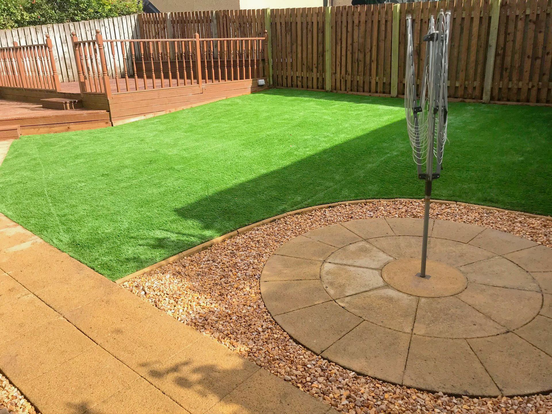 A lawn with a circle in the middle of it and a fence in the background after the clean-up project was completed.