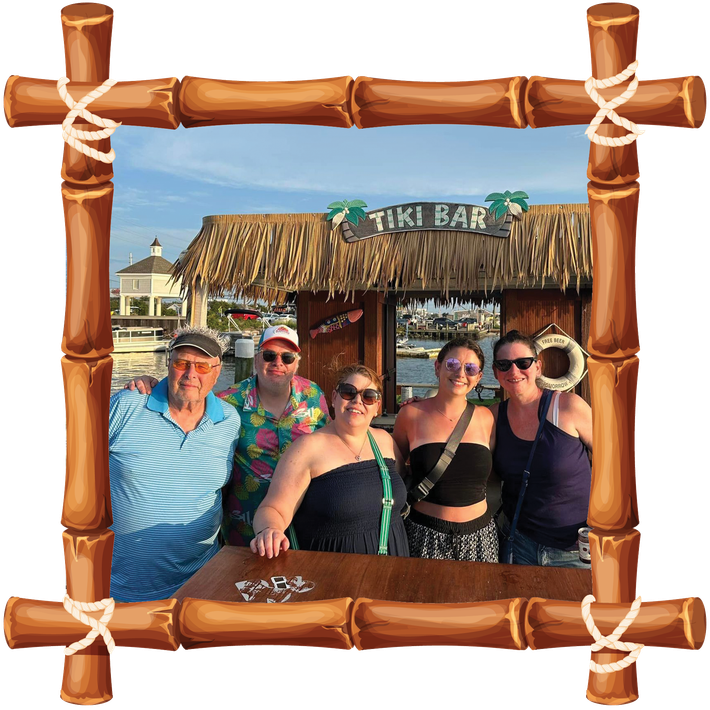Five friends posing in front of a tiki bar, framed by a bamboo-style border.