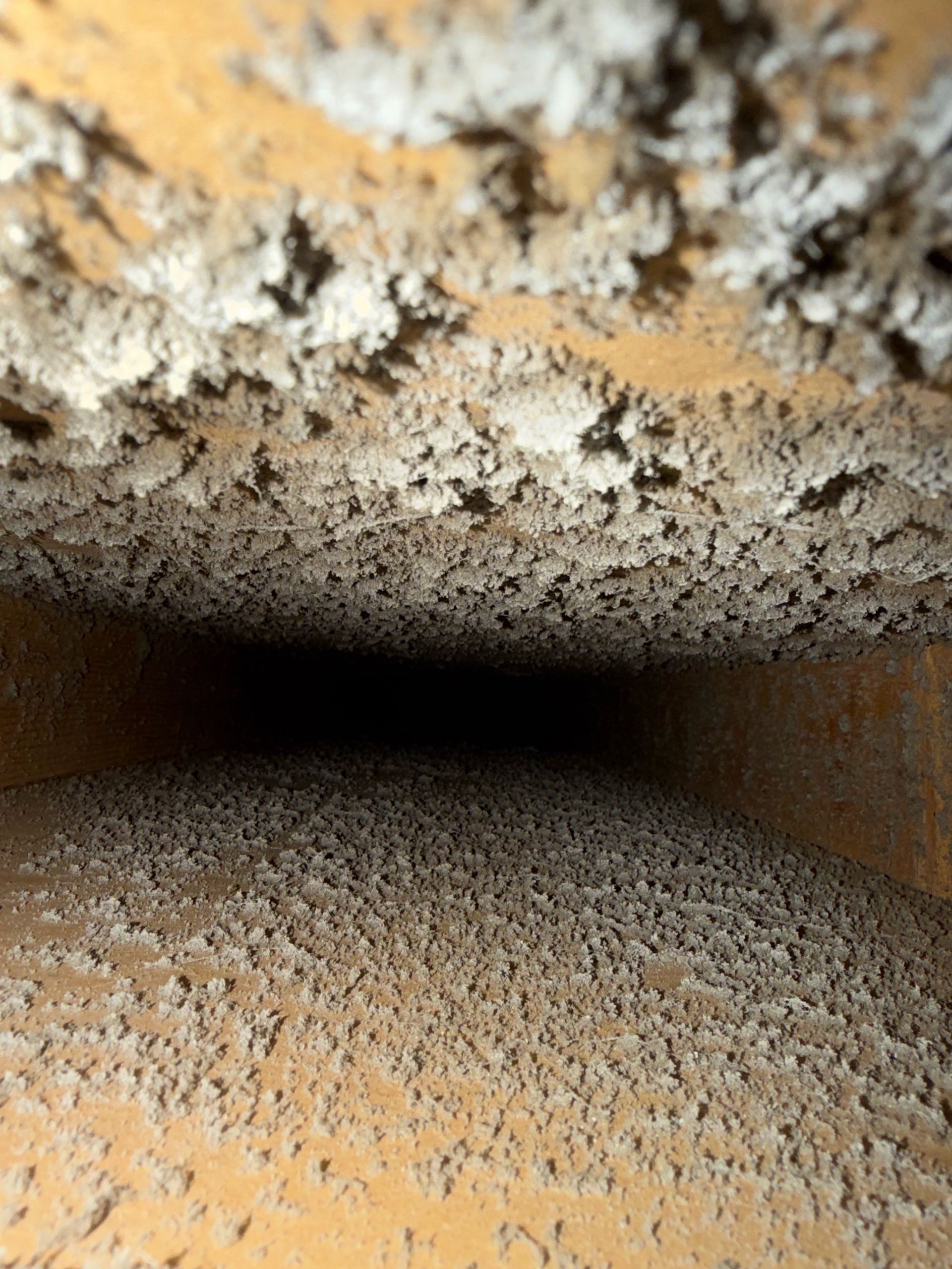 Rusty metal pipe interior with heavy corrosion and dark opening