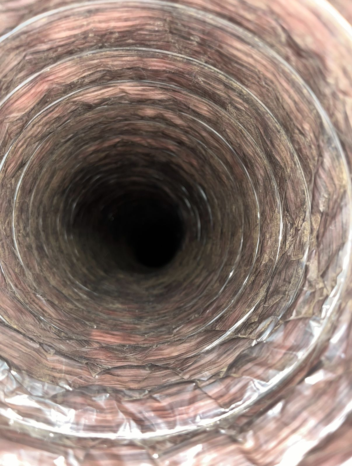 Close-up view down a rusted metal pipe with a dark, empty center.