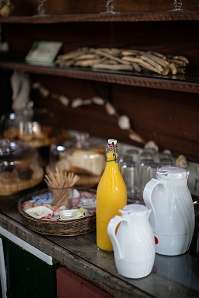 Breakfast buffet with orange juice, white pitchers, and pastries on a wooden counter