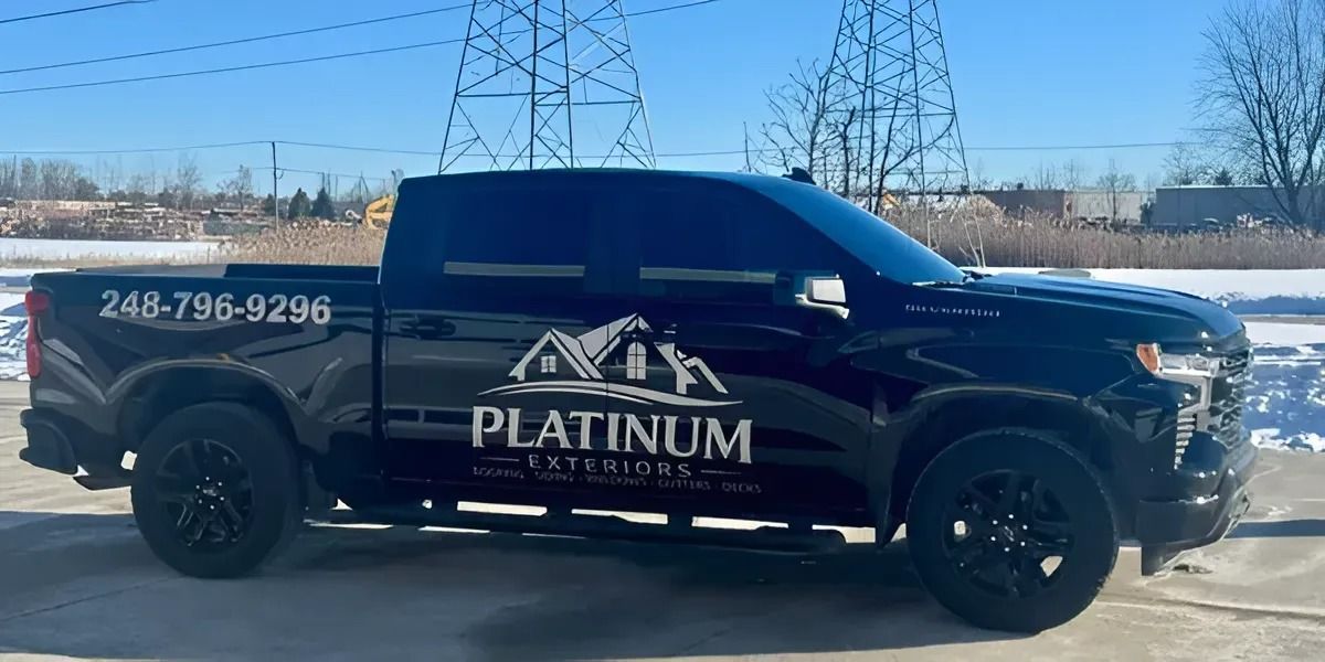 Black Platinum Landscaping pickup truck parked outdoors with company logo and phone number on the side
