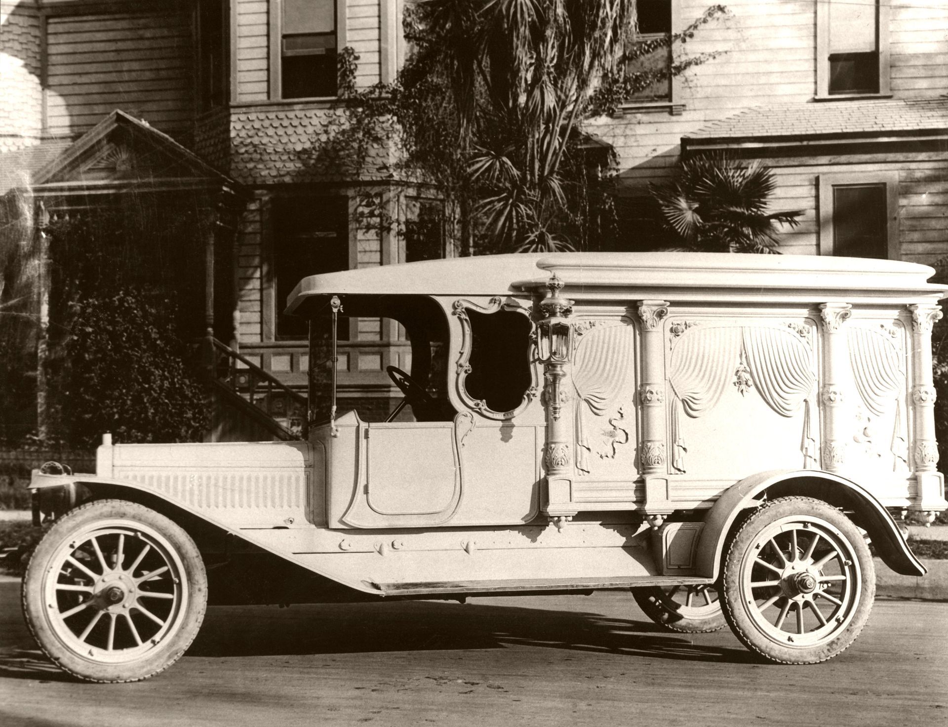 Vintage delivery truck parked on a street in front of houses