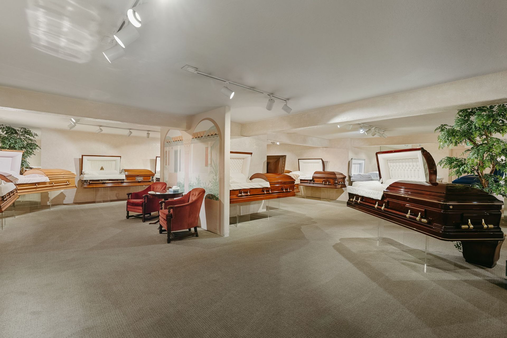 Spacious living room with carpet, white walls, red chairs, sofas, and a black piano near a plant