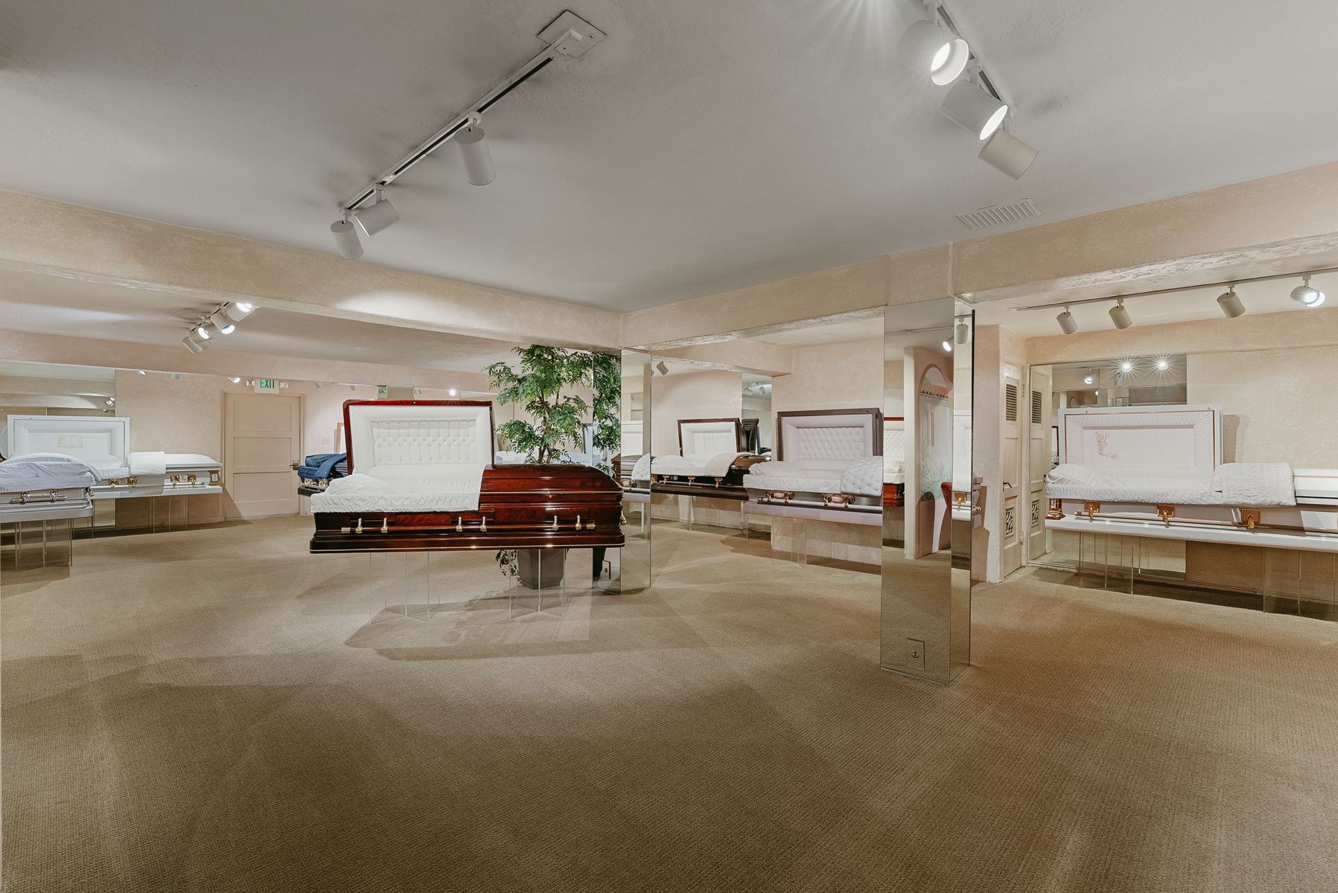 Spacious furniture showroom with beds, sofas, and display areas under bright ceiling lights.