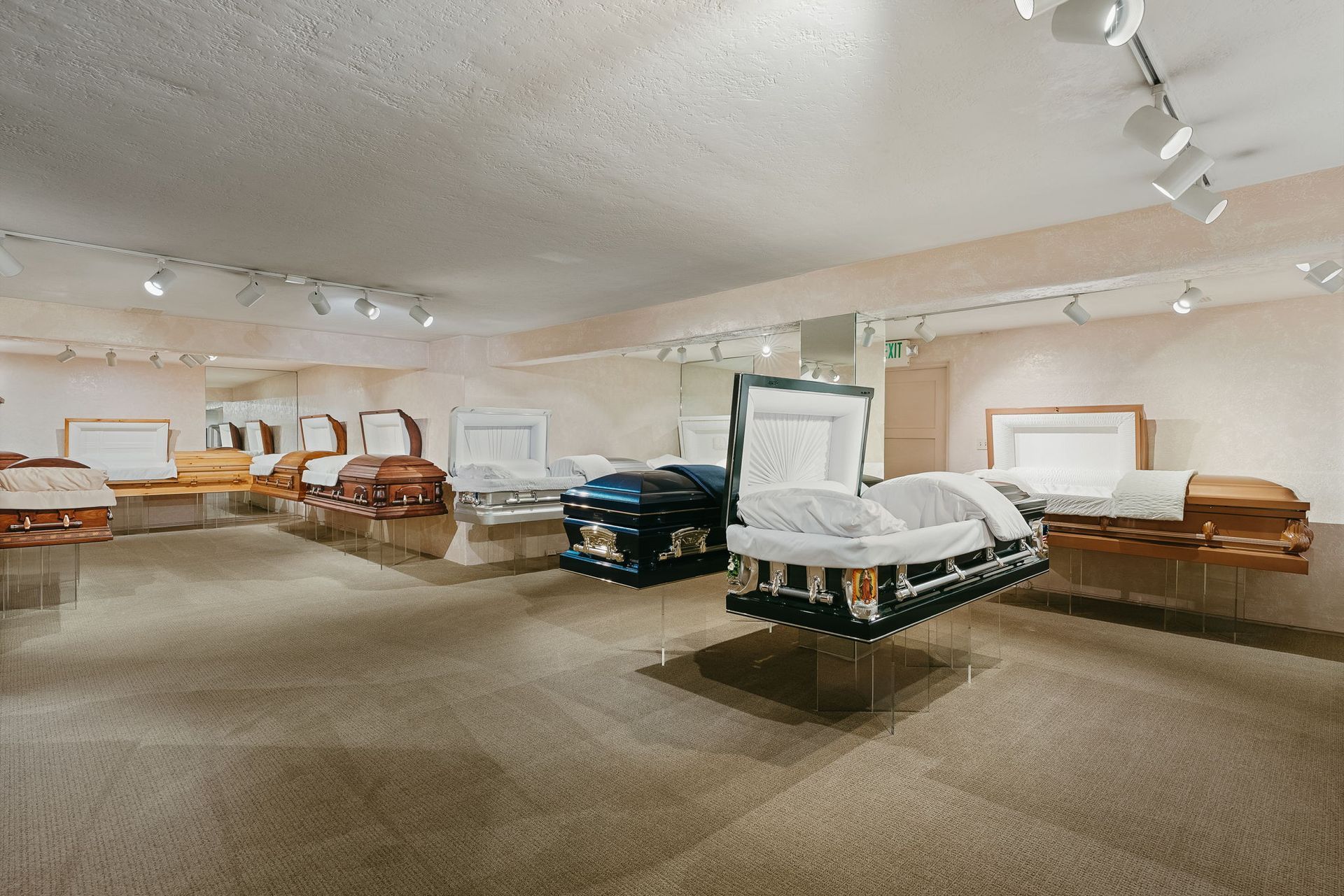 Furniture showroom with sofas, chairs, and display tables in a large carpeted room