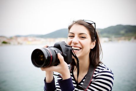 A woman is taking a picture with a canon camera