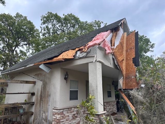 Severely damaged house with collapsed roof and torn exterior walls after storm or structural failure