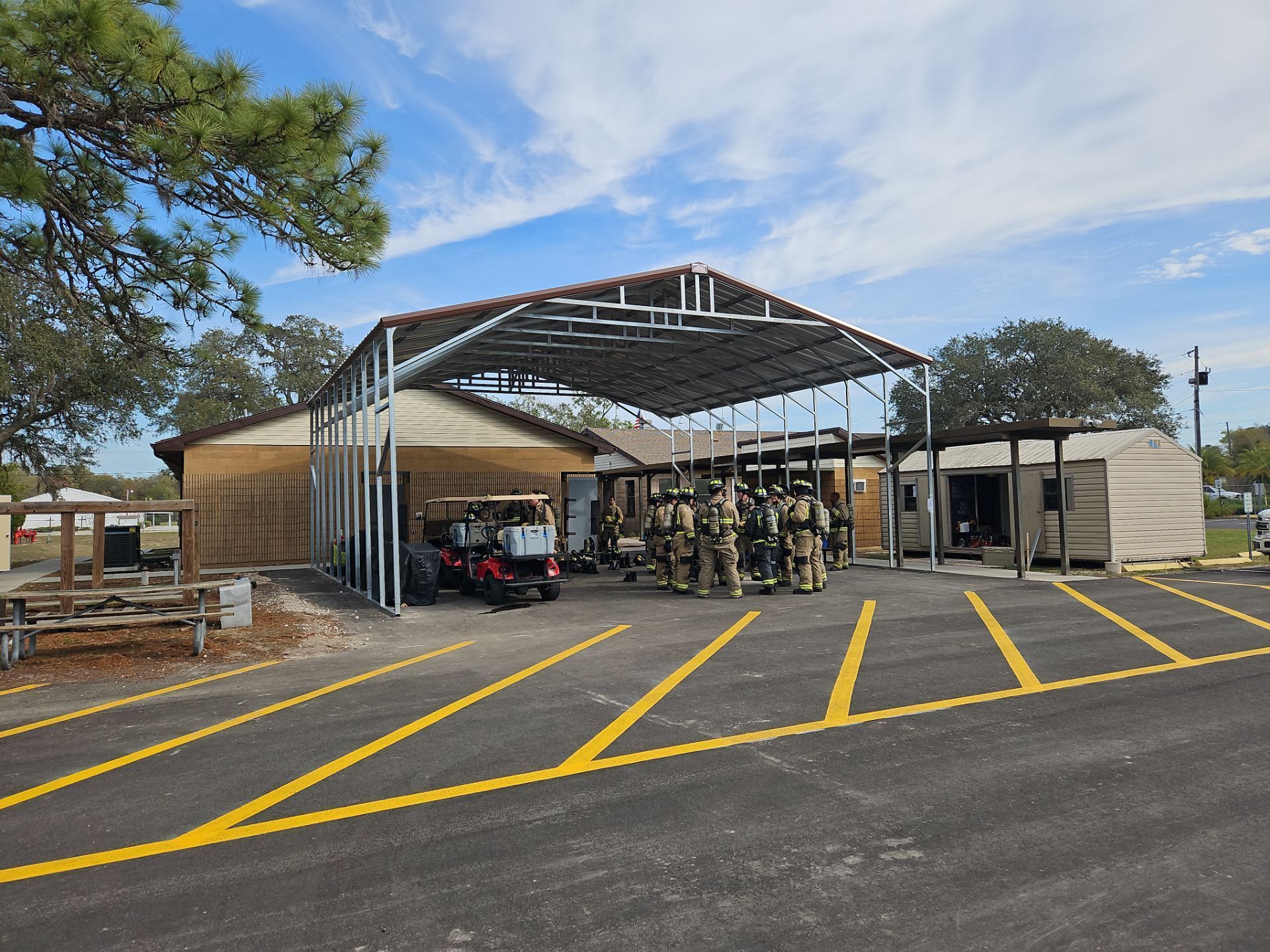 Covered cart return area in a parking lot with yellow lines and shopping carts beside a building