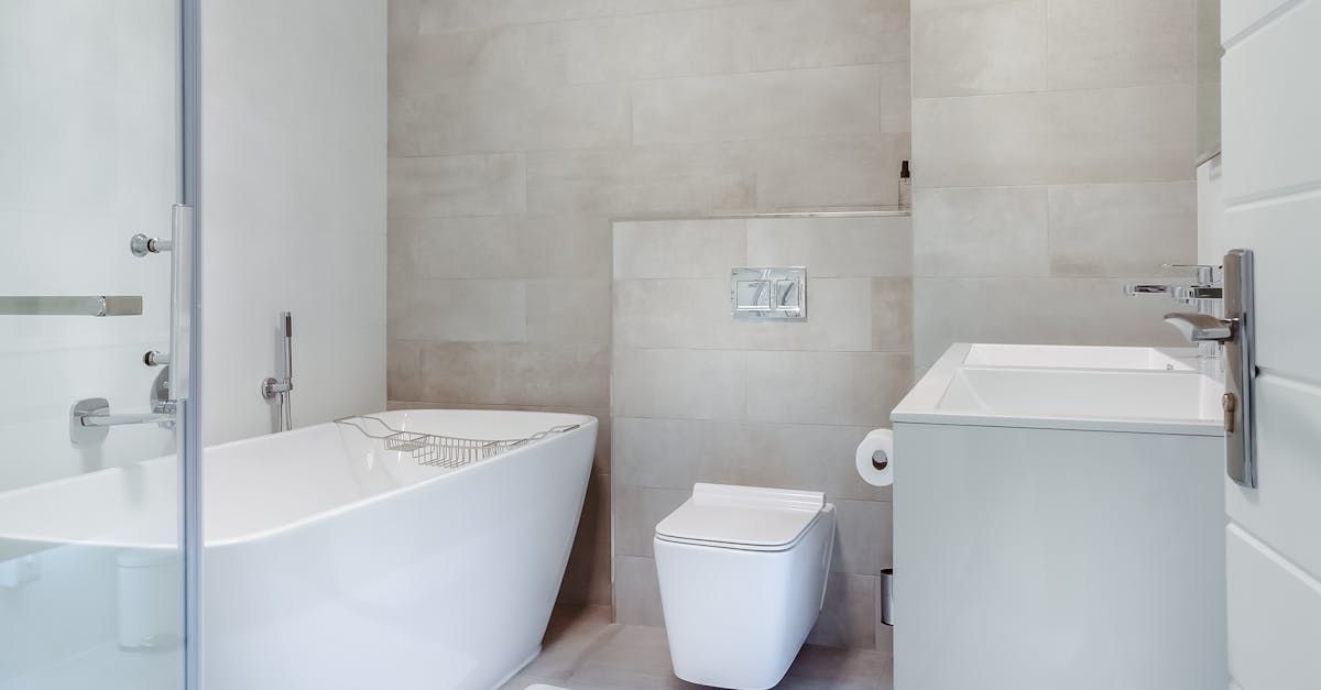 Modern white bathroom with freestanding tub, toilet, and vanity sink.