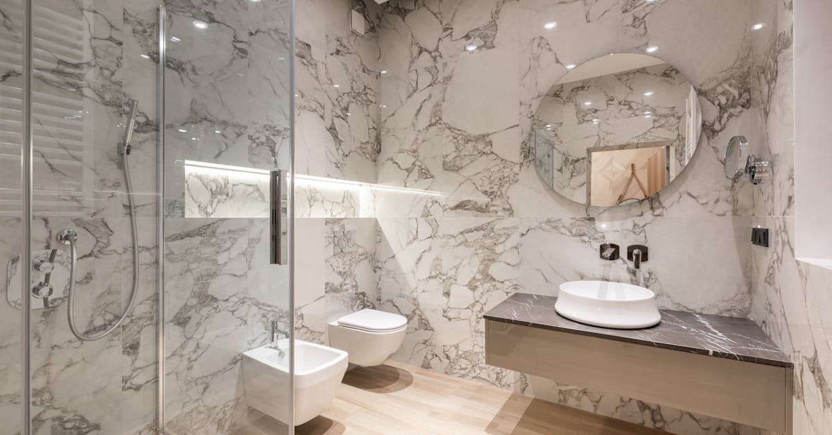 Elegant marble bathroom with walk-in shower, wall-mounted toilet, and vanity with round sink