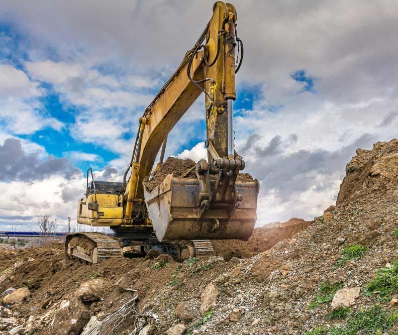 Excavator Loaded With Earth And Carrying Out A Clearing In A Work — Austen Landscaping & Earthmoving in Deeragun, QLD