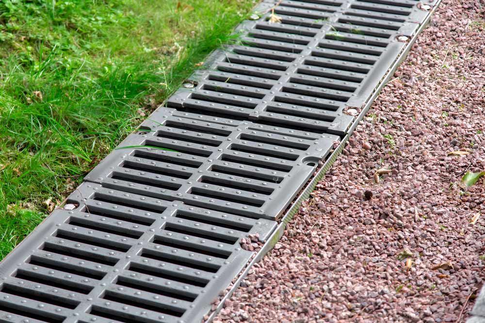 Landscape With Drainage And Pebbles And Green Grass — Austen Landscaping & Earthmoving in Deeragun, QLD