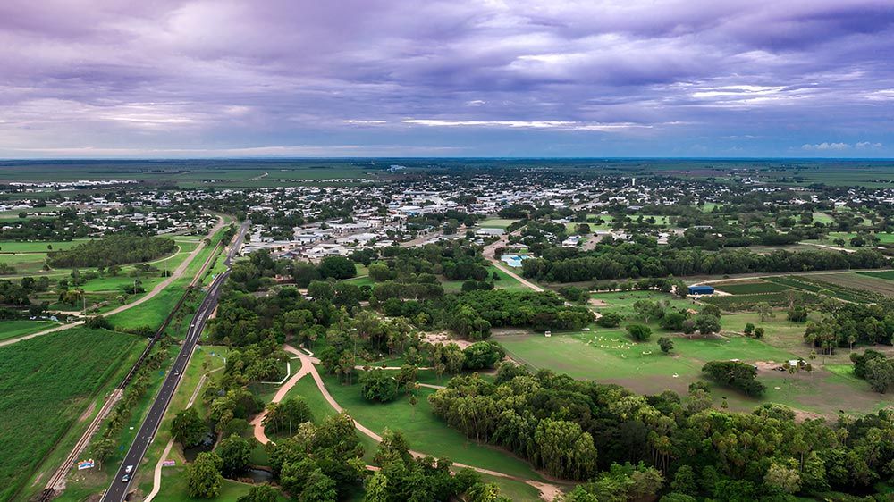 An Aerial View Of A City Surrounded By Trees And Fields — Austen Landscaping & Earthmoving in Ayr, QLD