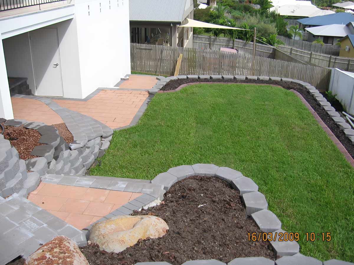 Lush Green Lawn With Retaining Wall With A Fence — Austen Landscaping & Earthmoving in Deeragun, QLD